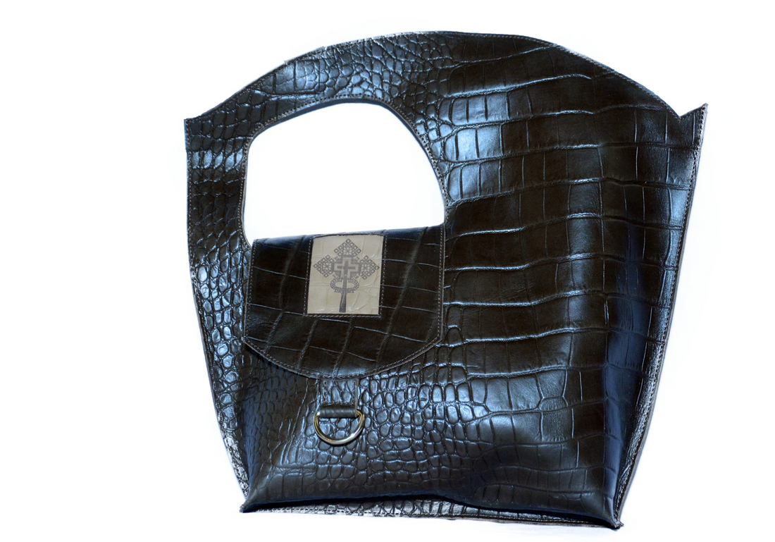 Black crocodile-patterned handbag on a white background